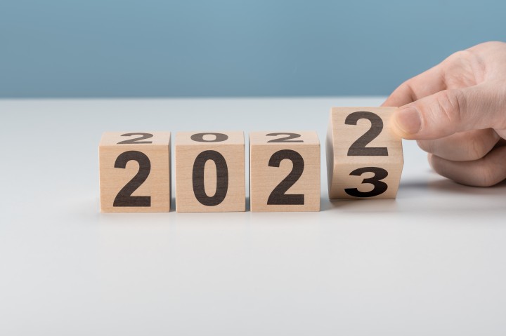 Vier mit Zahlen beschriftete Holzklötze, das letzte Kltötzchen wird von einer Hand umgedreht, sodass aus der 2022 eine 2023 wird.
(c) iStock-1387428341